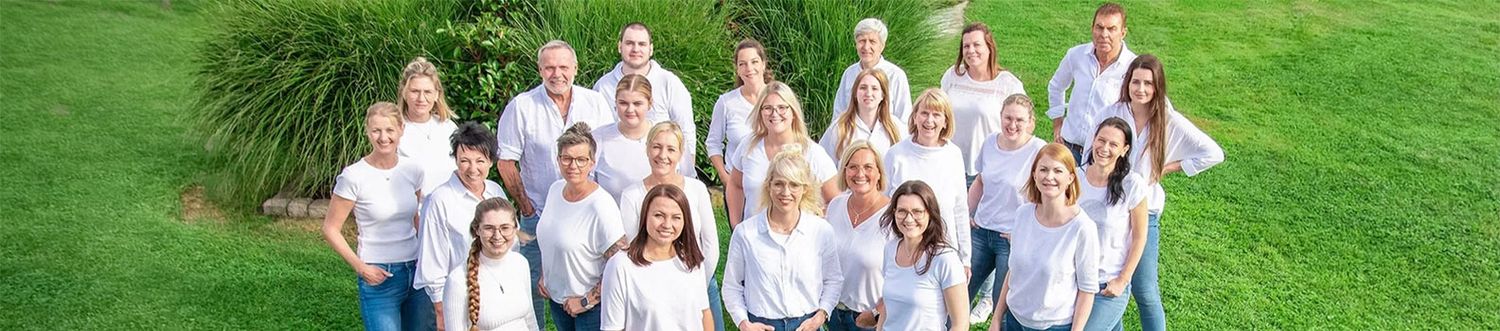 Teambild der Mitarbeiter auf einer Wiese